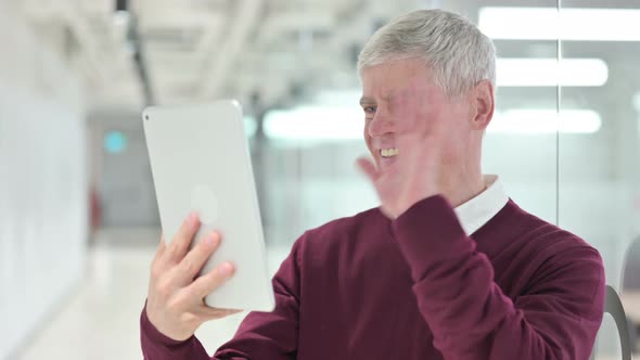 Middle Aged Man Doing Video Chat on Tablet  alt