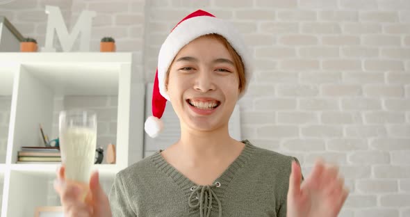 Asian woman wearing hat having video call celebrating Christmas online