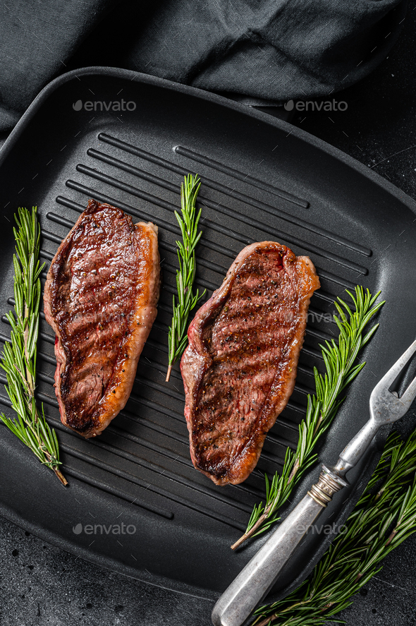 Grilled Top sirloin beef steak or brazilian Picanha, roasted meat on grill pan. Stock Photo by