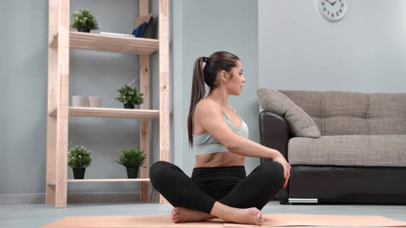 Smiling Flexible Woman Sitting in Lotus Position Warming Up Stretching Spine Practicing Morning Yoga alt