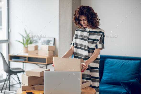 Concentrated store worker packing goods for shipping - Stock Photo - Images