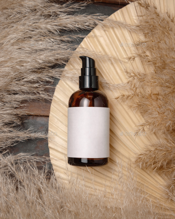 Cosmetic one pump bottle on dried palm leaf near pampas grass top view. Label Mockup