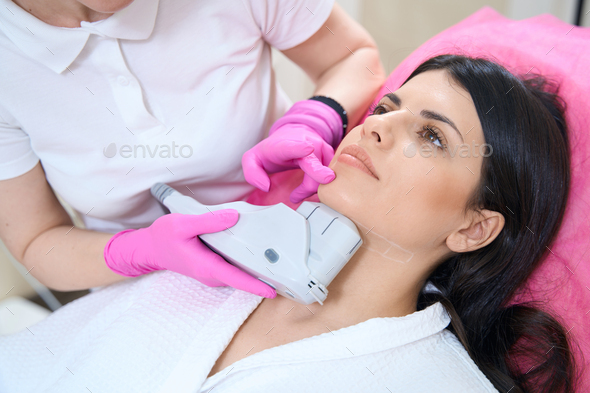 Patient undergoing an ultrasonic lifting procedure to tighten the skin on chin
