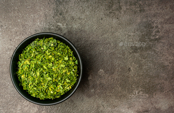 Dried Parsley Leaves from a flat lay angle with a dramatic dark background.