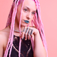 Modern and tattooed young girl with colored braids in the studio in front of a pink background - PhotoDune Item for Sale