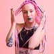 Modern and tattooed young girl with colored braids in the studio in front of a pink background - PhotoDune Item for Sale