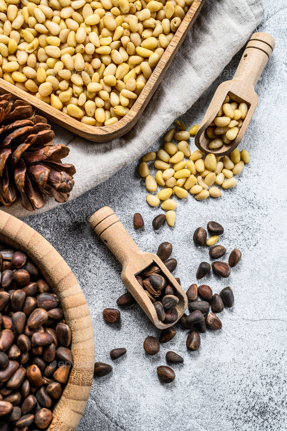 pine nuts peeled and in the shell. Gray background. Top view Stock