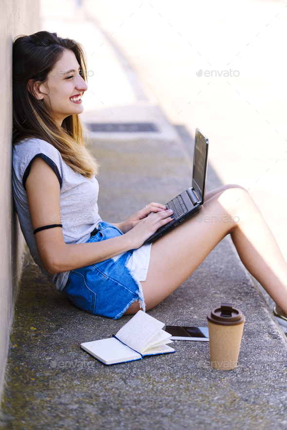 Digital nomad girl working from a natural setting. Stock Photo by armacuatro