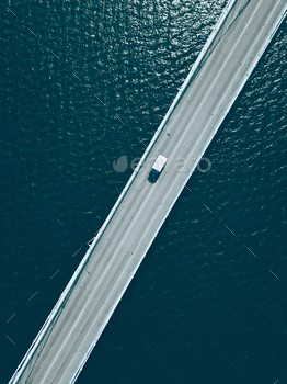 Aerial top view of bridge road with cars over blue lake