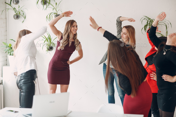 Team women doing exercises in office. Exercising females at work. Benefits of fitness and gymnastics - Stock Photo - Images