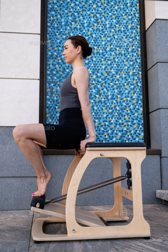 Pilates reformer chair woman fitness yoga gym exercise. Stock Photo by