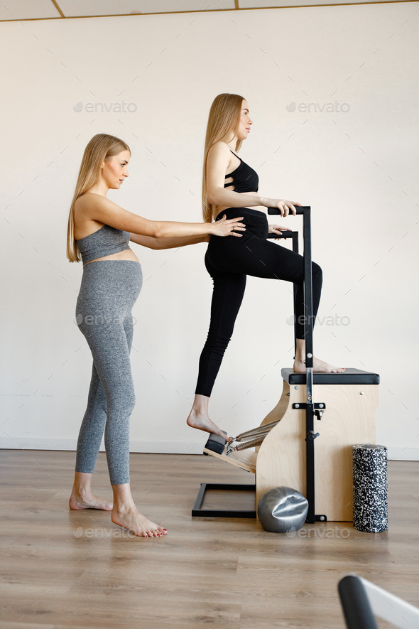 Barefoot woman stretching on pilates ladder barrel Stock Photo by