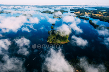 Aerial top view of mist cloud fog morning over blue lakes and green forests in Finland.