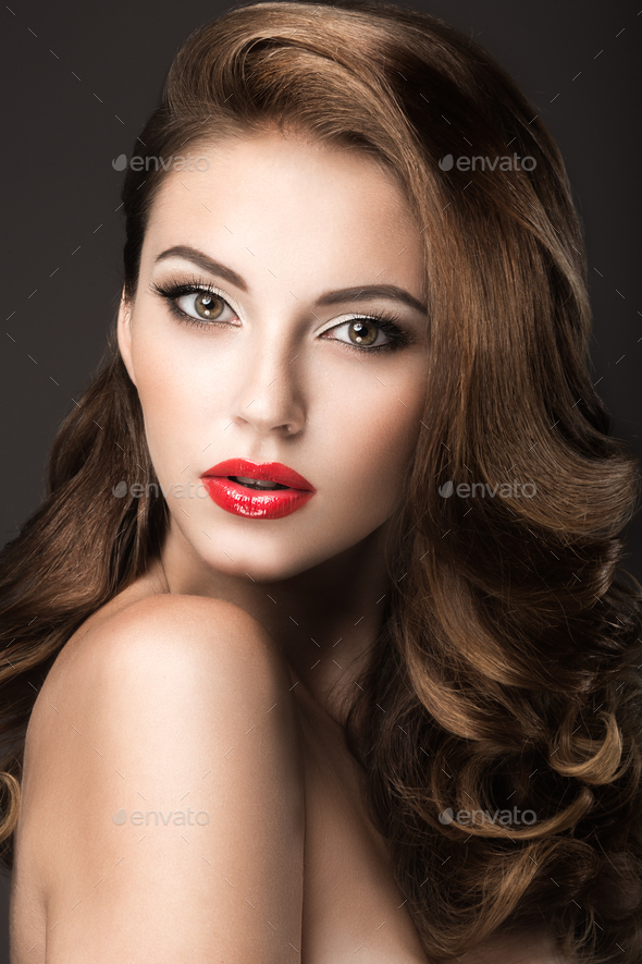 Beautiful woman with evening make-up, red lips and curls. Beauty face ...