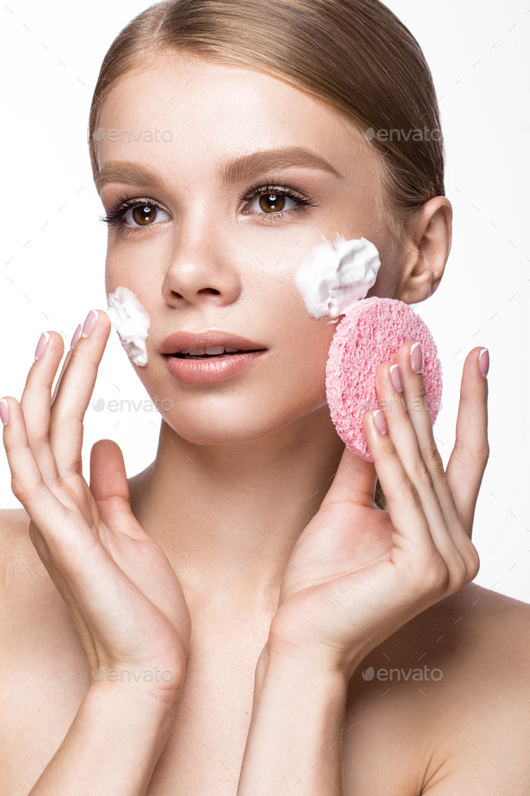 Beautiful young girl with sponge and foam cleanser, French manicure. Beauty face.