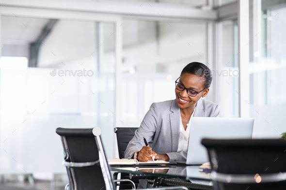 Successful black woman manager writing notes - Stock Photo - Images