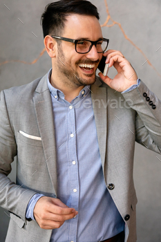 Portrait of young successful businessman with digital device working in corporate business office