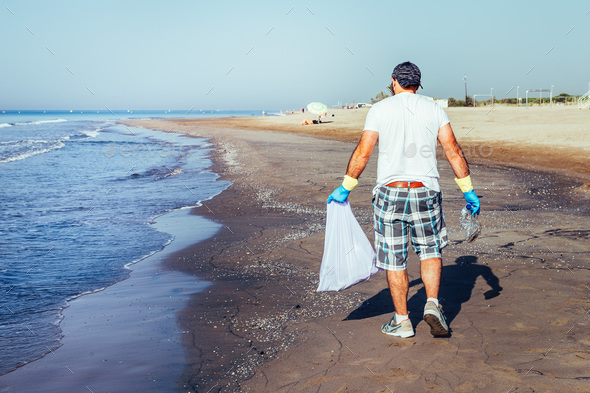 volunteer picking up waste that pollute the sea