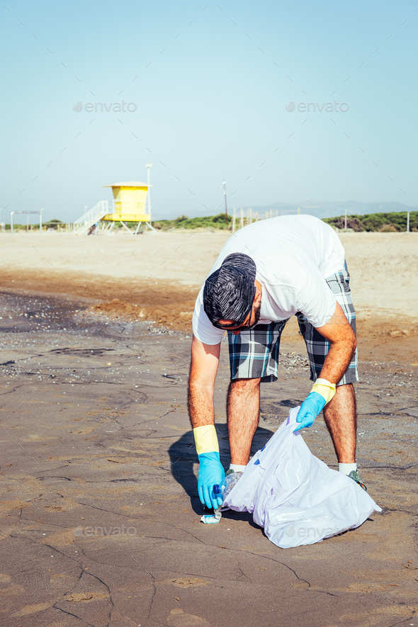 volunteer picking up waste that pollute the ocean