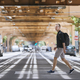 Man with backpack walking on pedestrian crosswalk uder elevated railway - PhotoDune Item for Sale
