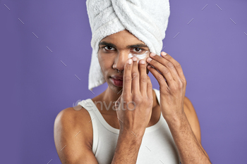 Close up portrait of young african american man use gel eye anti-wrinkle patche in