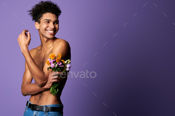 Smiling muscular transgender model with bouquet portrait. Nude torso young man of trans gender