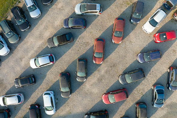 Aerial view of many colorful cars parked on dealer parking lot for sale