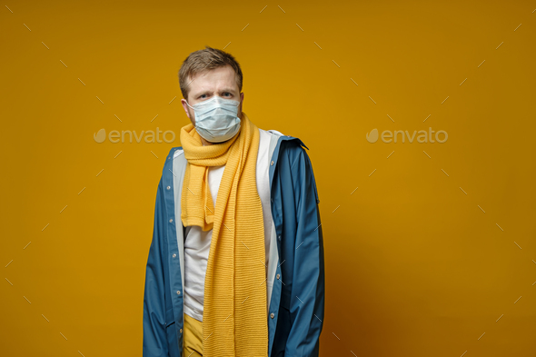 Perplexed man in a medical mask, looks anxiously at the camera. Concept of the spread of the virus.