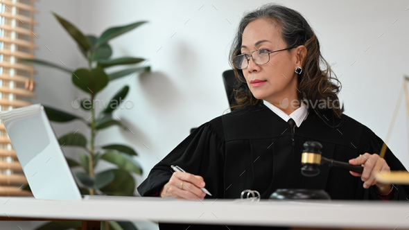 female judge holding gavel hammer mallet, talking to her clients for ...