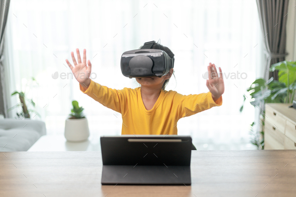 Cute girl wearing virtual reality googles at home, - Stock Photo - Images