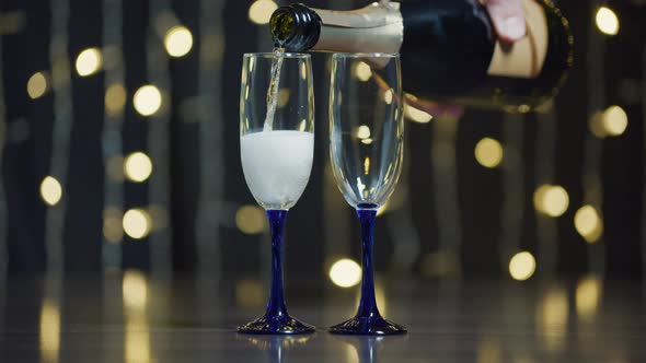 Glasses with champagne for New Year and Christmas on a flickering background (2)