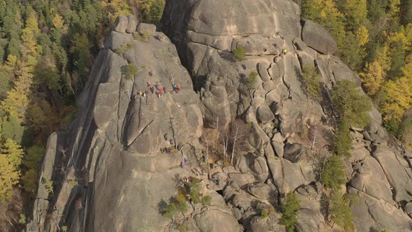 A Team of Climbers Training on a High Rock.