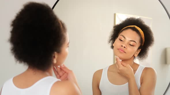 African american woman holding cotton pad disk cleaning face skin with cleanser tonic remove make up alt