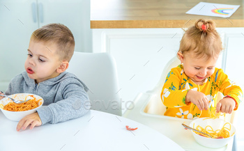 children in the kitchen at the table turning pasta.