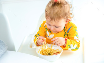 children in the kitchen at the table turning pasta.