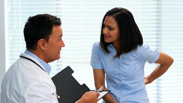 Patient suffering from stomach ache while consulting doctor alt