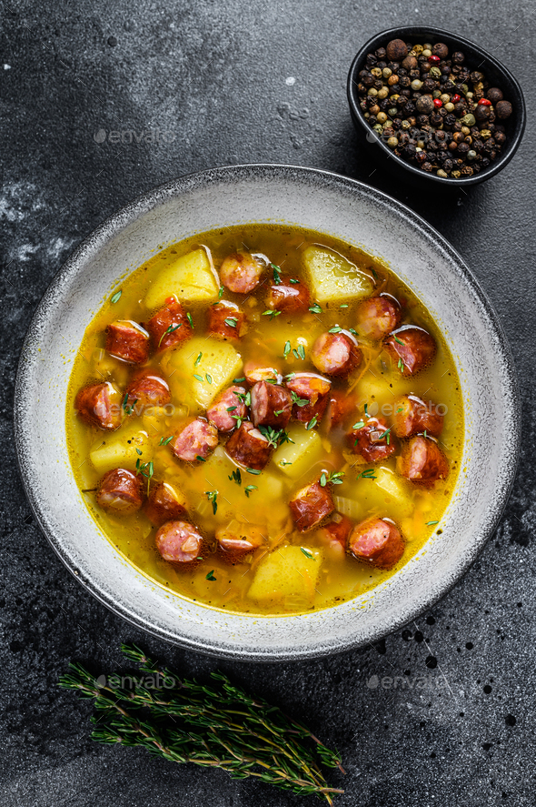 German Split pea soup with smoked sausages and meat. Black background