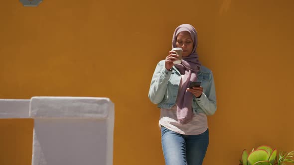 Young woman wearing hijab out and about in the city alt