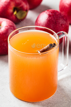 Homemade hot apple cider in glass cup. Autumn or winter warming drink.