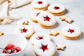Christmas strawberry linzer cookies on gray background. Festive dessert, winter treat.