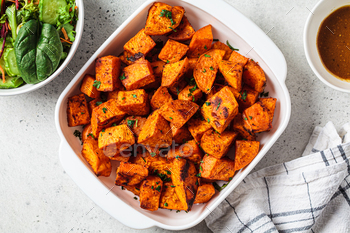Spicy slices of baked sweet potato. Vegan food concept.