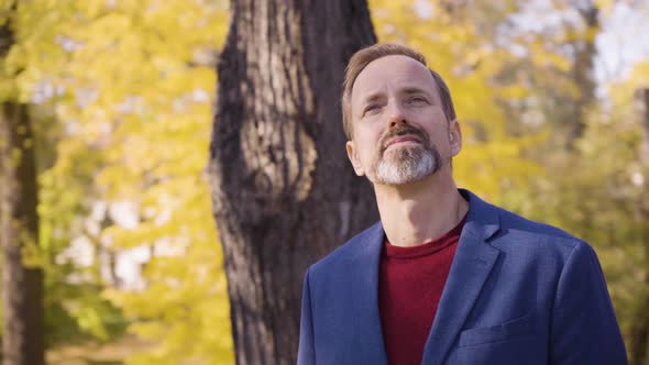 A Middleaged Handsome Caucasian Man Looks Around in a Park in Fall