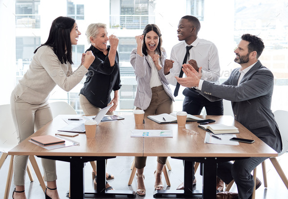 Every success is a team effort. Shot of a group of businesspeople cheering in a meeting at work.