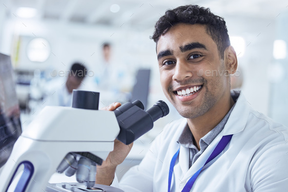 Shot of a young male lab technician using a microscope