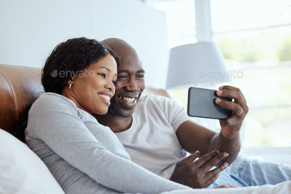 We start and end with the family. Shot of a young couple using a smartphone in bed at home.