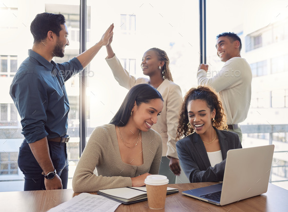 Every success is a team effort. Shot of a group of businesspeople celebrating in an office at work.