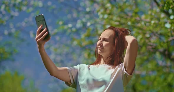 Adult Woman is Taking Selfie By Smartphone in Blooming Garden in Spring Day  Prores