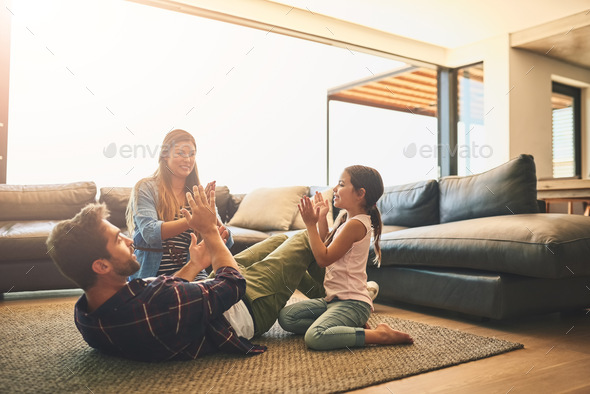 Shot of a happy family of three playing a clapping game together at home