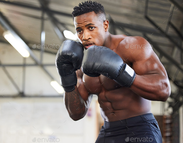 Ill knockout every challenge. Shot of a muscular young man wearing boxing gloves in a gym.