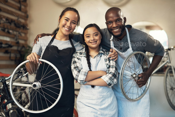 Come inside. Portrait of three young workers at a bicycle repair shop.
